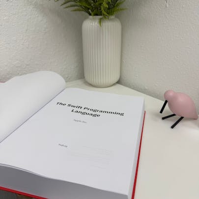 Photo of The Swift Programming Language as a physical print textbook. The book is displayed open showcasing the inside cover.