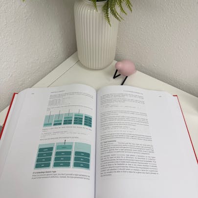 Photo of The Swift Programming Language as a physical print textbook. The book is displayed open showcasing the print media.