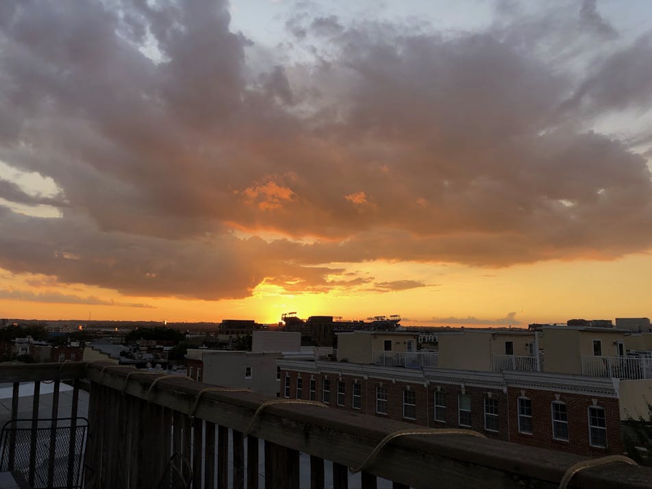 Sun setting behind stadium in the distance.