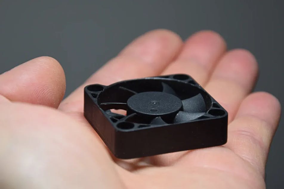 A small fan in the hand of a technician.