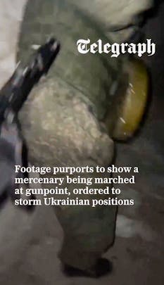 A person in military gear stands against a brick wall, with text discussing accusations against Russia regarding forced recruits.